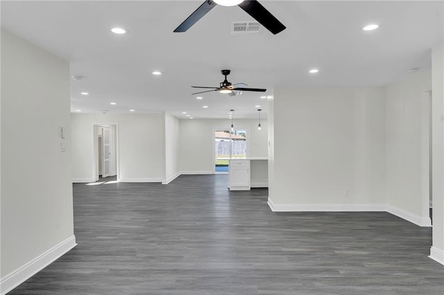 unfurnished living room featuring ceiling fan and dark wood-type flooring