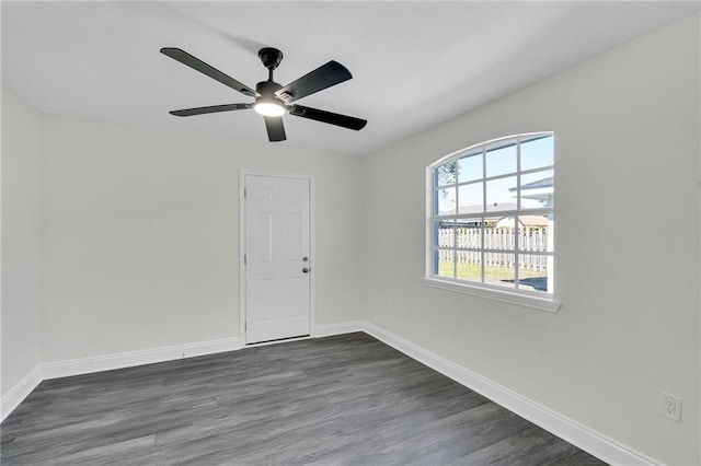 empty room with dark hardwood / wood-style flooring and ceiling fan