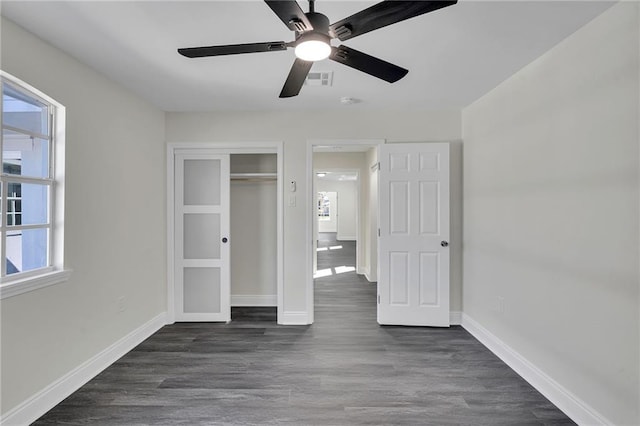 unfurnished bedroom with a closet, ceiling fan, and dark hardwood / wood-style flooring