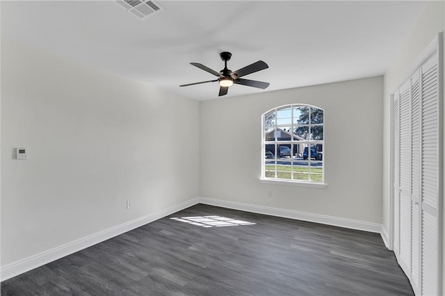 unfurnished bedroom featuring ceiling fan, dark hardwood / wood-style floors, and a closet