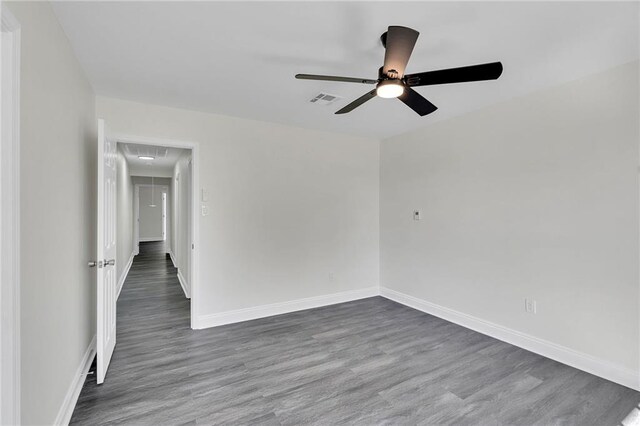 unfurnished room with dark hardwood / wood-style floors and ceiling fan