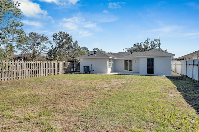 rear view of property featuring a patio, central AC, and a lawn