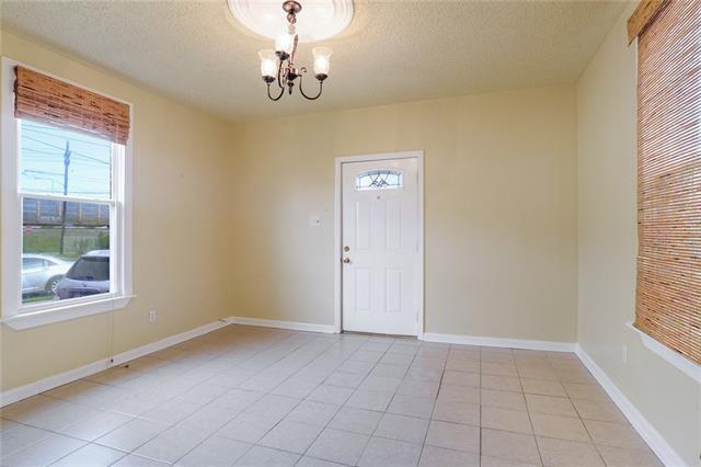 tiled spare room featuring a textured ceiling and a notable chandelier