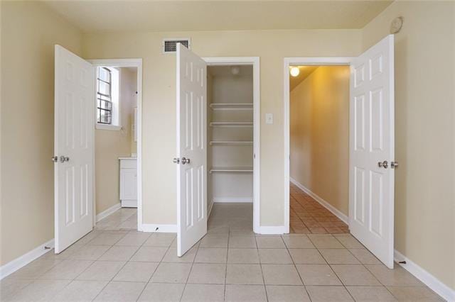 unfurnished bedroom featuring light tile patterned floors and a closet