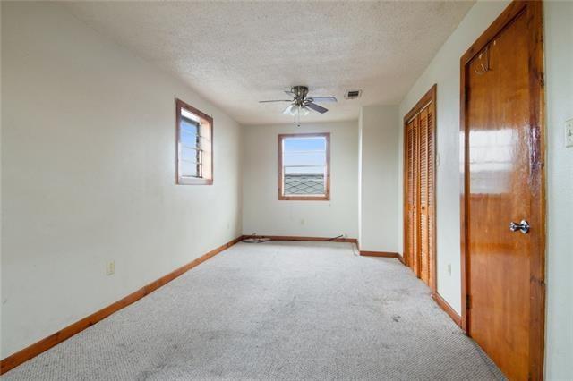 empty room featuring light carpet, a textured ceiling, and ceiling fan