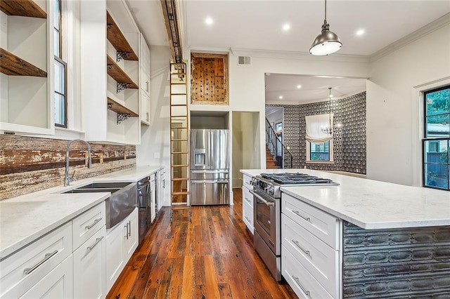 kitchen featuring pendant lighting, light stone countertops, stainless steel appliances, and white cabinets