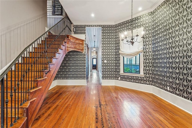 interior space with hardwood / wood-style floors, a notable chandelier, and ornamental molding