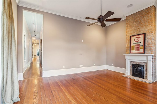 unfurnished living room with hardwood / wood-style floors, a fireplace, ornamental molding, and ceiling fan