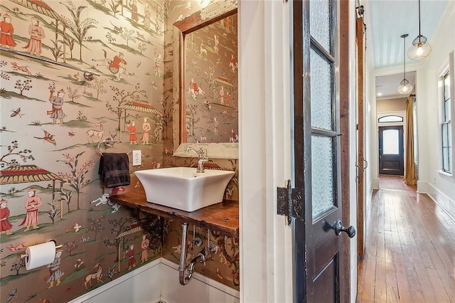 bathroom with sink, crown molding, and wood-type flooring