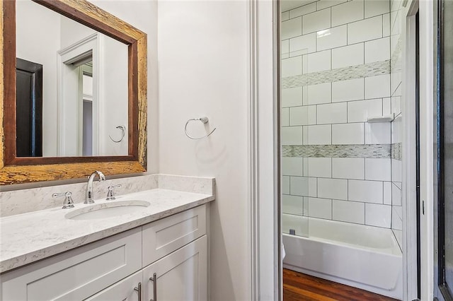 bathroom featuring tiled shower / bath combo, vanity, and hardwood / wood-style floors