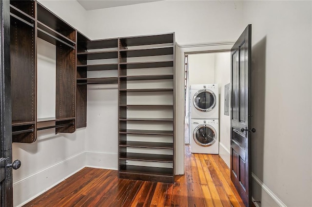 washroom featuring dark wood-type flooring and stacked washer and clothes dryer