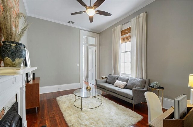 living room with dark hardwood / wood-style flooring, ceiling fan, and ornamental molding