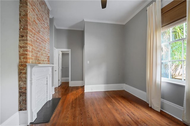 unfurnished living room featuring a fireplace, dark wood-type flooring, and ornamental molding