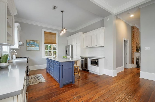 kitchen with a breakfast bar, dark wood-type flooring, blue cabinetry, white cabinets, and a center island