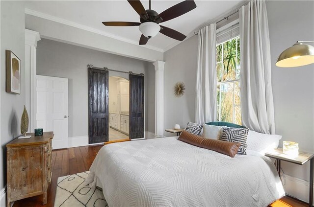 bedroom with hardwood / wood-style floors, ceiling fan, ornamental molding, and ensuite bath