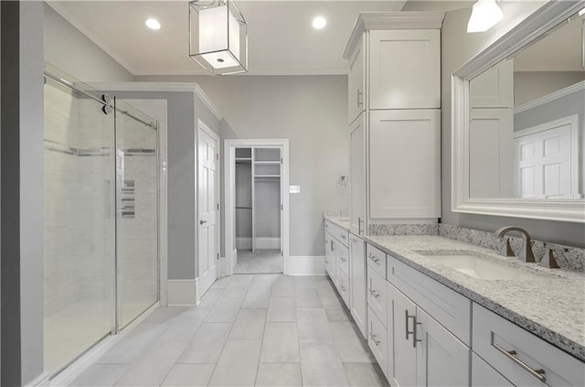 bathroom featuring tile patterned floors, vanity, ornamental molding, and a shower with door