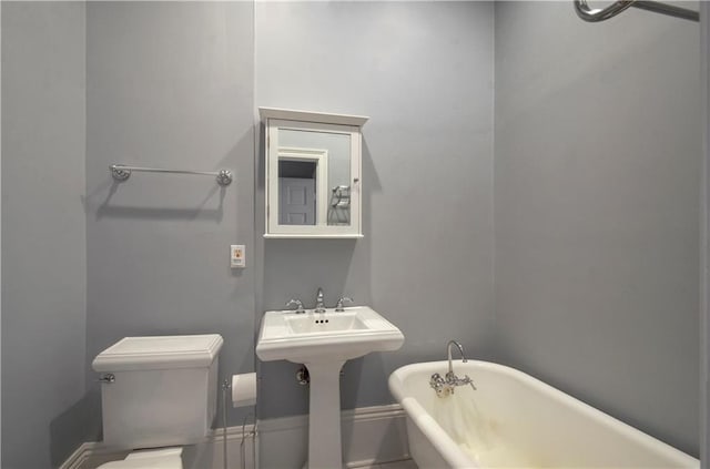 bathroom with a washtub and toilet