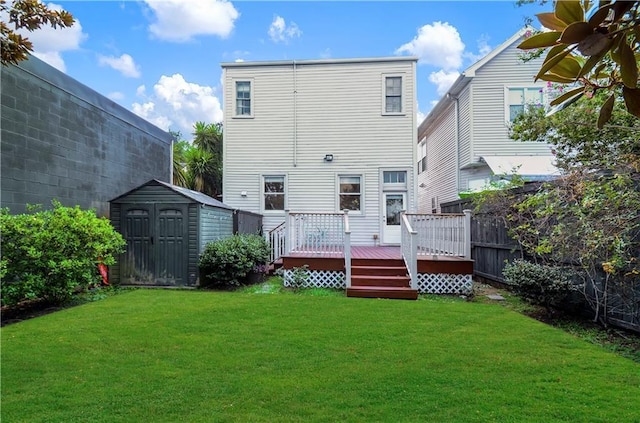 rear view of property featuring a lawn, a shed, and a wooden deck