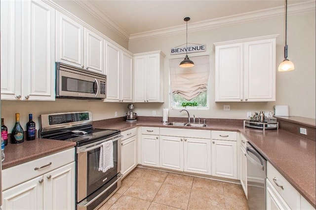 kitchen with sink, white cabinets, decorative light fixtures, and appliances with stainless steel finishes