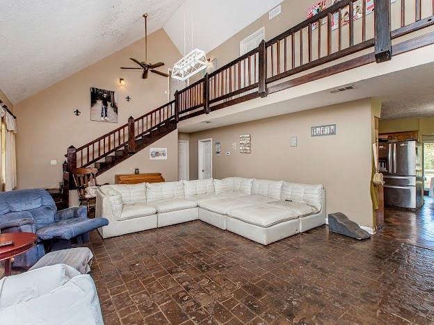 living room featuring high vaulted ceiling and ceiling fan