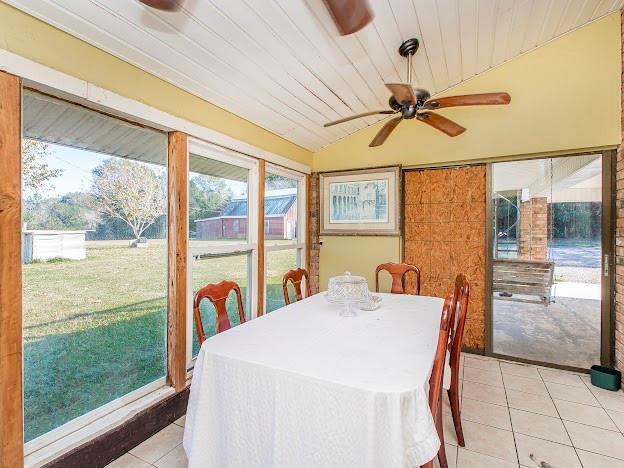 dining area featuring lofted ceiling, ceiling fan, light tile patterned floors, and wood ceiling