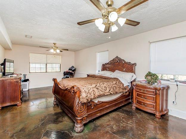 bedroom with a textured ceiling and ceiling fan