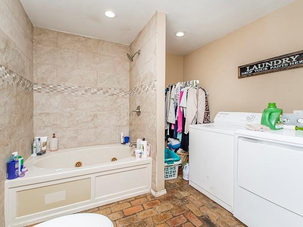 bathroom with washer and dryer and tiled shower / bath