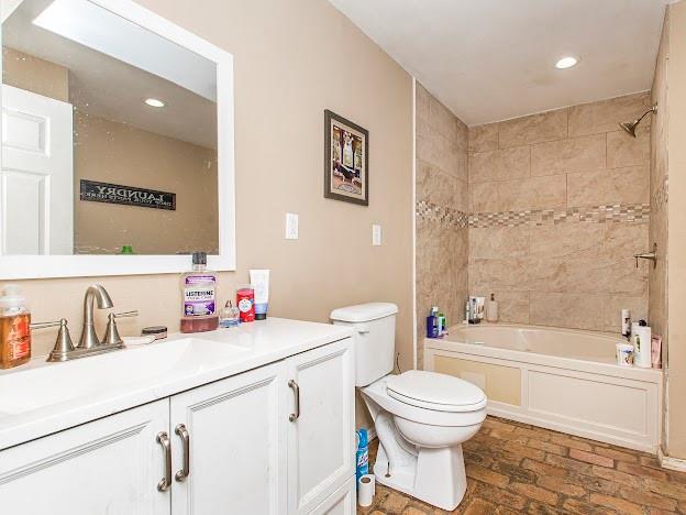 full bathroom with vanity, toilet, and tiled shower / bath