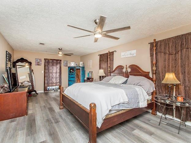 bedroom featuring a textured ceiling, hardwood / wood-style flooring, and ceiling fan