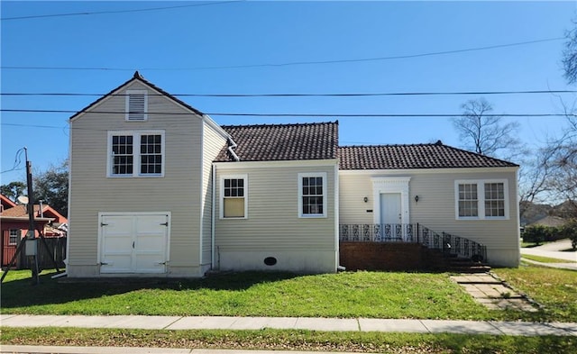 view of front of property featuring a tile roof and a front lawn