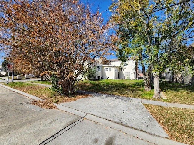 obstructed view of property featuring a front lawn and fence