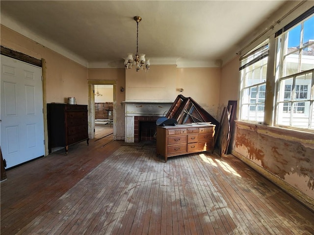 unfurnished living room with an inviting chandelier and hardwood / wood-style flooring