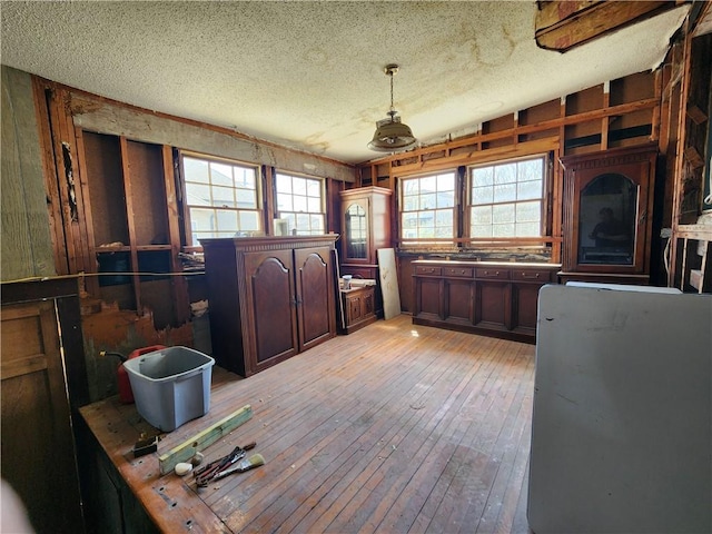 unfurnished office featuring light wood finished floors and a textured ceiling