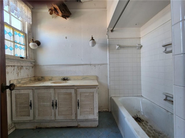 full bath featuring vanity, tile walls, bathtub / shower combination, and wainscoting