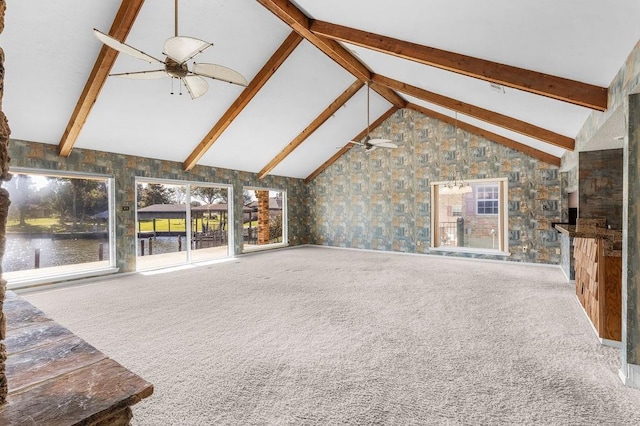 unfurnished living room featuring carpet flooring, ceiling fan, and lofted ceiling with beams