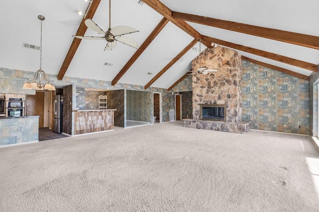 unfurnished living room with beam ceiling, ceiling fan, dark colored carpet, high vaulted ceiling, and a fireplace