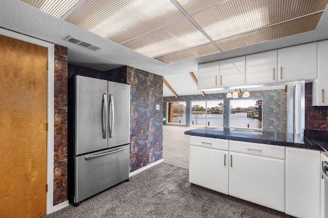 kitchen with carpet, stainless steel fridge, a water view, white cabinetry, and lofted ceiling