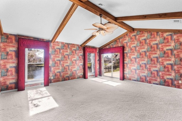 unfurnished living room with carpet flooring, lofted ceiling with beams, and ceiling fan