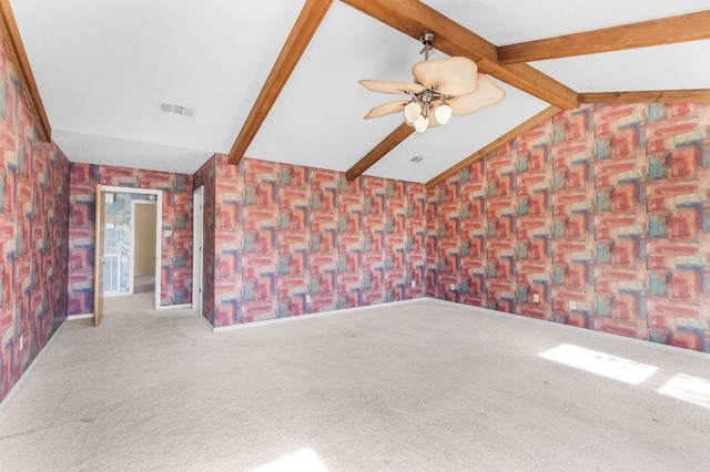 unfurnished living room with vaulted ceiling with beams, ceiling fan, and carpet floors