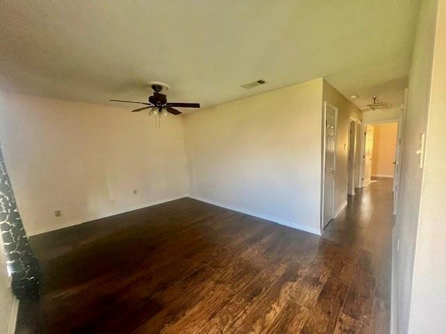 empty room with ceiling fan and dark hardwood / wood-style flooring