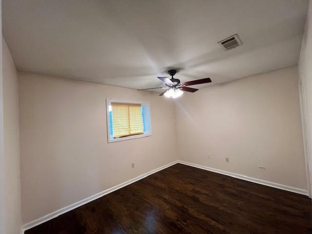 unfurnished room with ceiling fan and dark hardwood / wood-style flooring