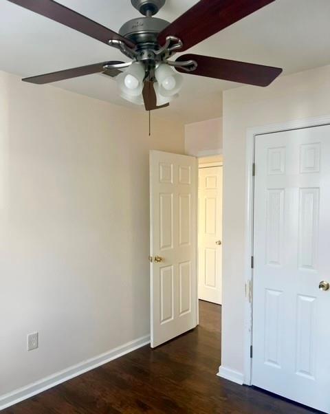 unfurnished bedroom featuring ceiling fan and dark hardwood / wood-style floors