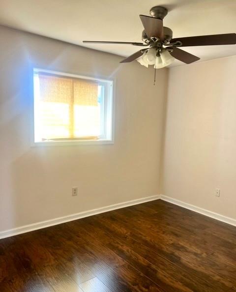 empty room featuring ceiling fan and dark hardwood / wood-style flooring