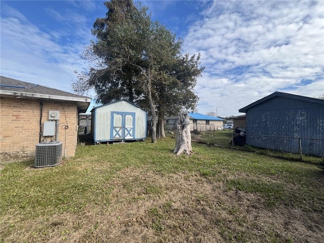 view of yard with central AC unit and a storage shed