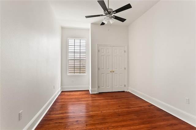 empty room with dark hardwood / wood-style floors and ceiling fan