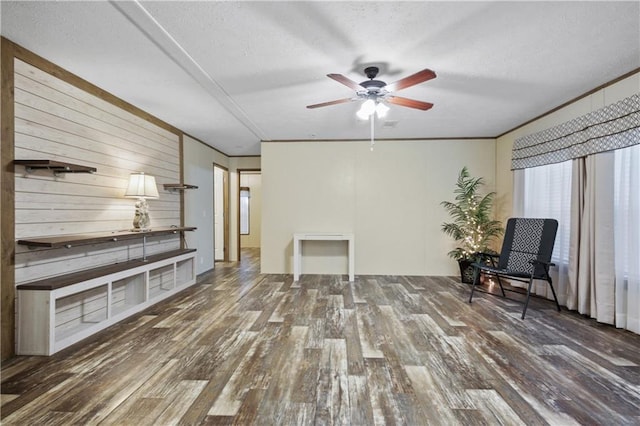 unfurnished room featuring ceiling fan, wooden walls, dark wood-type flooring, and a textured ceiling