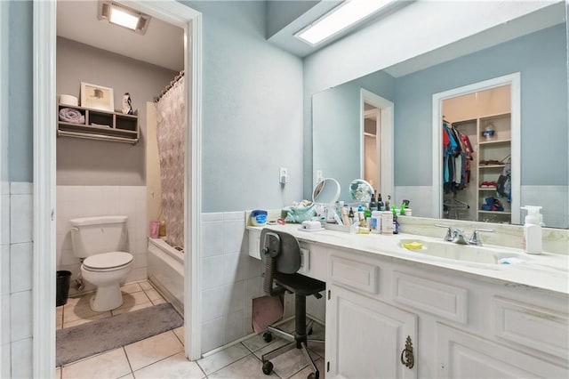 full bathroom featuring tile patterned floors, vanity, shower / bath combo with shower curtain, tile walls, and toilet