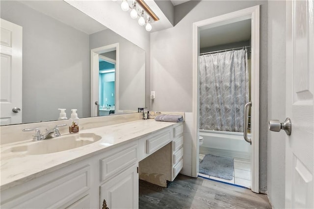 full bathroom with toilet, shower / tub combo with curtain, vanity, and hardwood / wood-style flooring