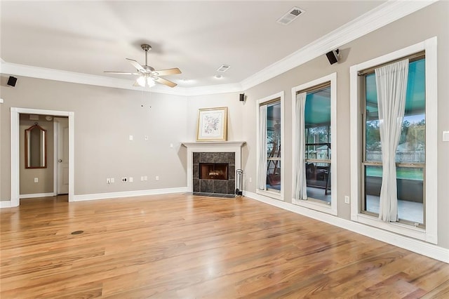 unfurnished living room with ceiling fan, ornamental molding, and light wood-type flooring