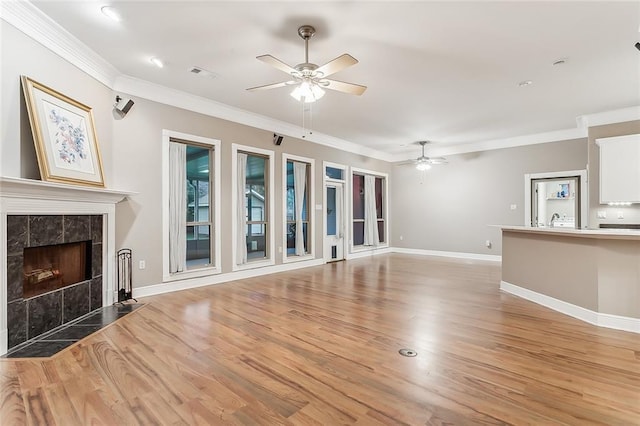 unfurnished living room featuring a fireplace, hardwood / wood-style flooring, ceiling fan, and ornamental molding